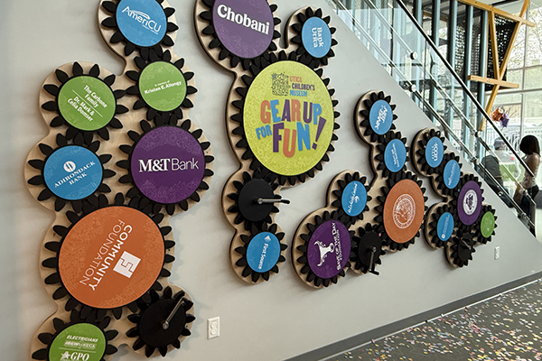 Utica Children's Museum Interior wall with different-sized gears showing the museum's donors.